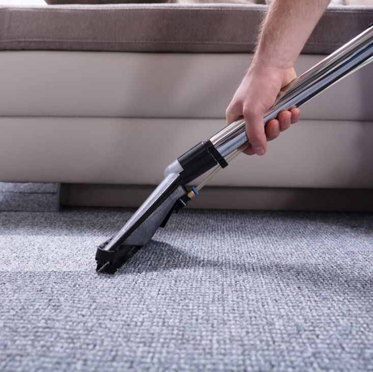 Worker steam cleaning carpet
